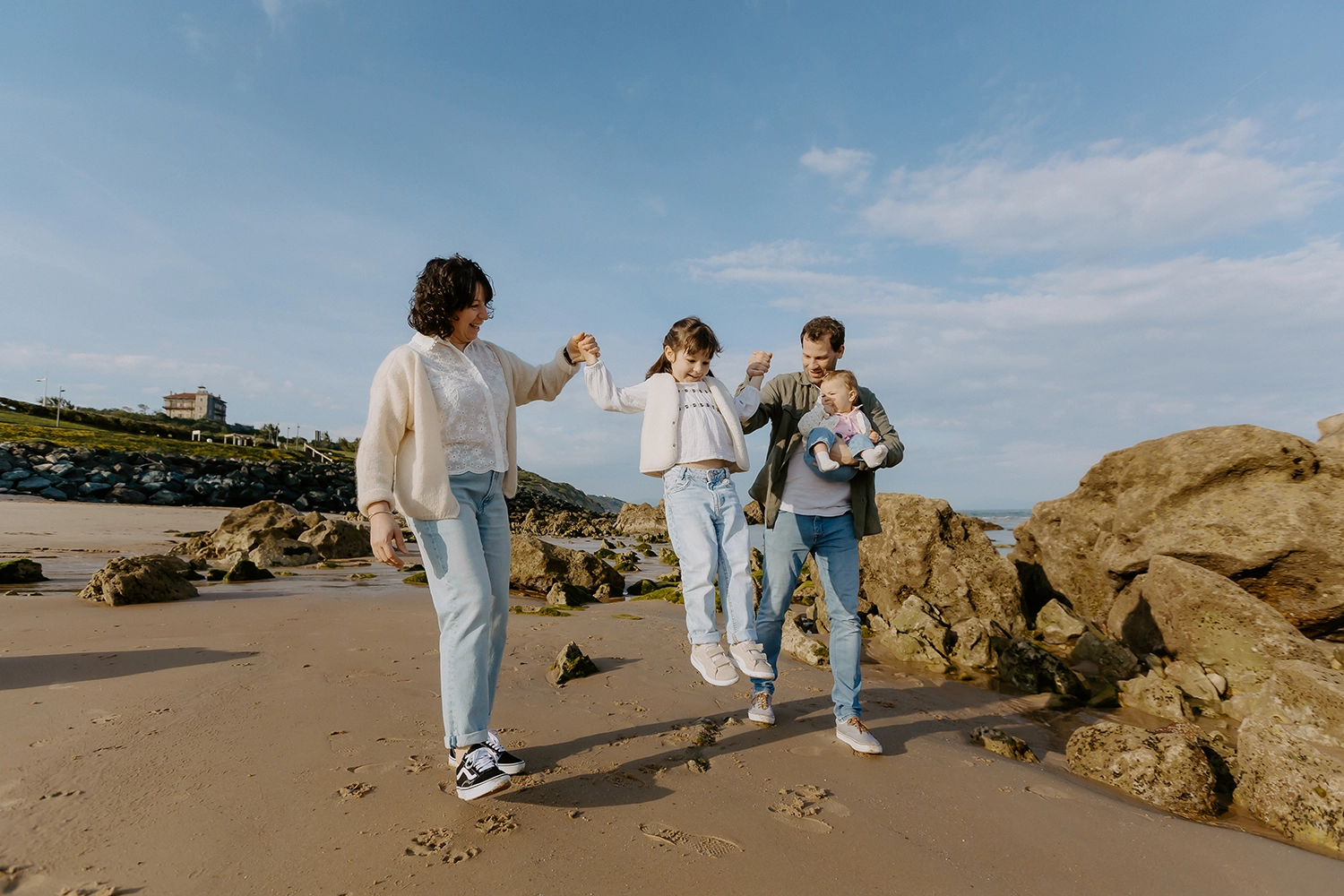 Famille unie sur le sable durant une séance de photos de famille sur la plage à Biarritz
