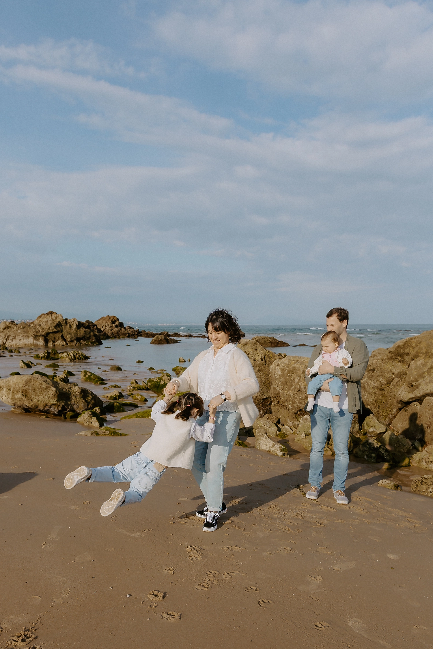 Famille unie sur le sable durant une séance de photos de famille sur la plage à Biarritz