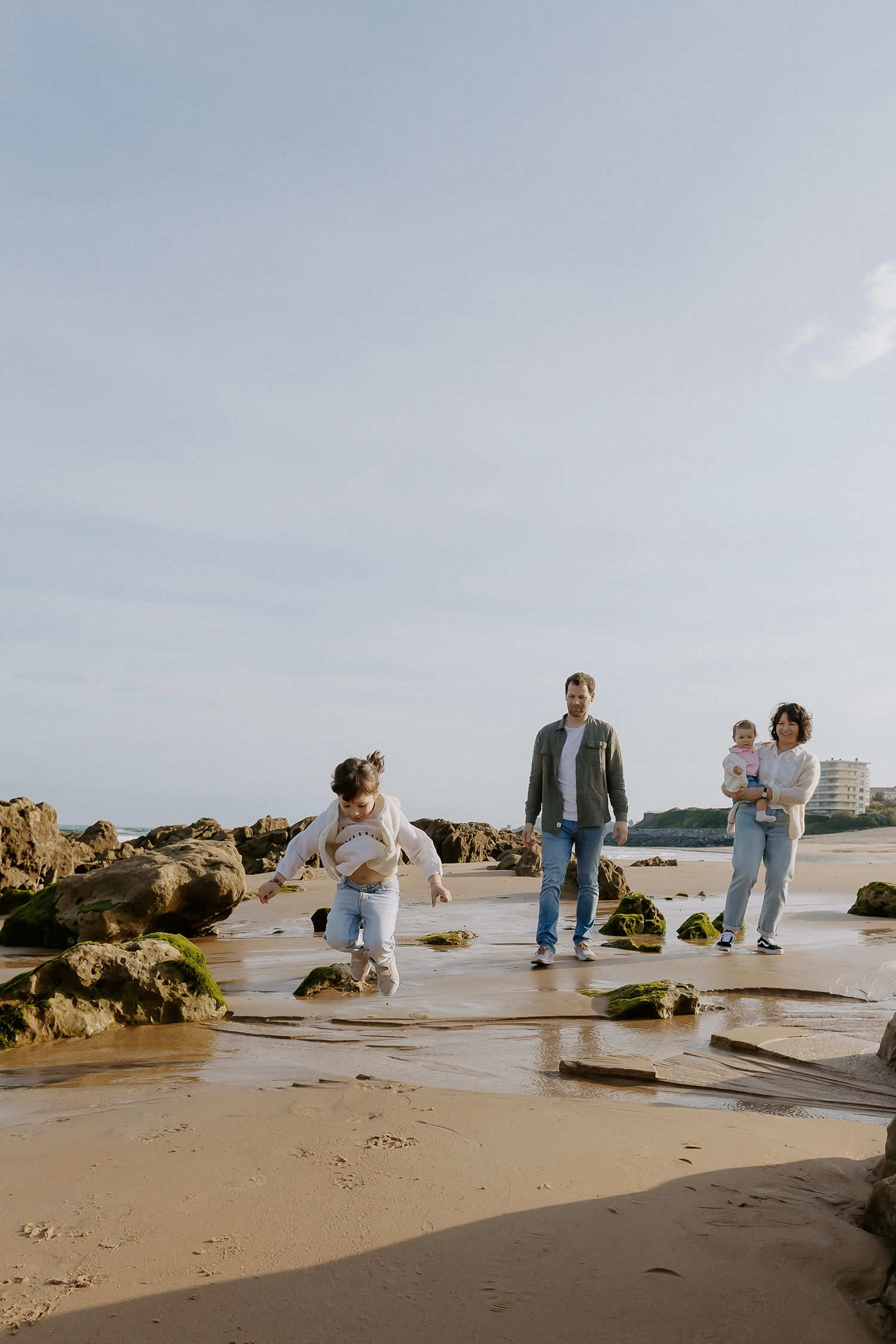 Famille unie sur le sable durant une séance de photos de famille sur la plage à Biarritz