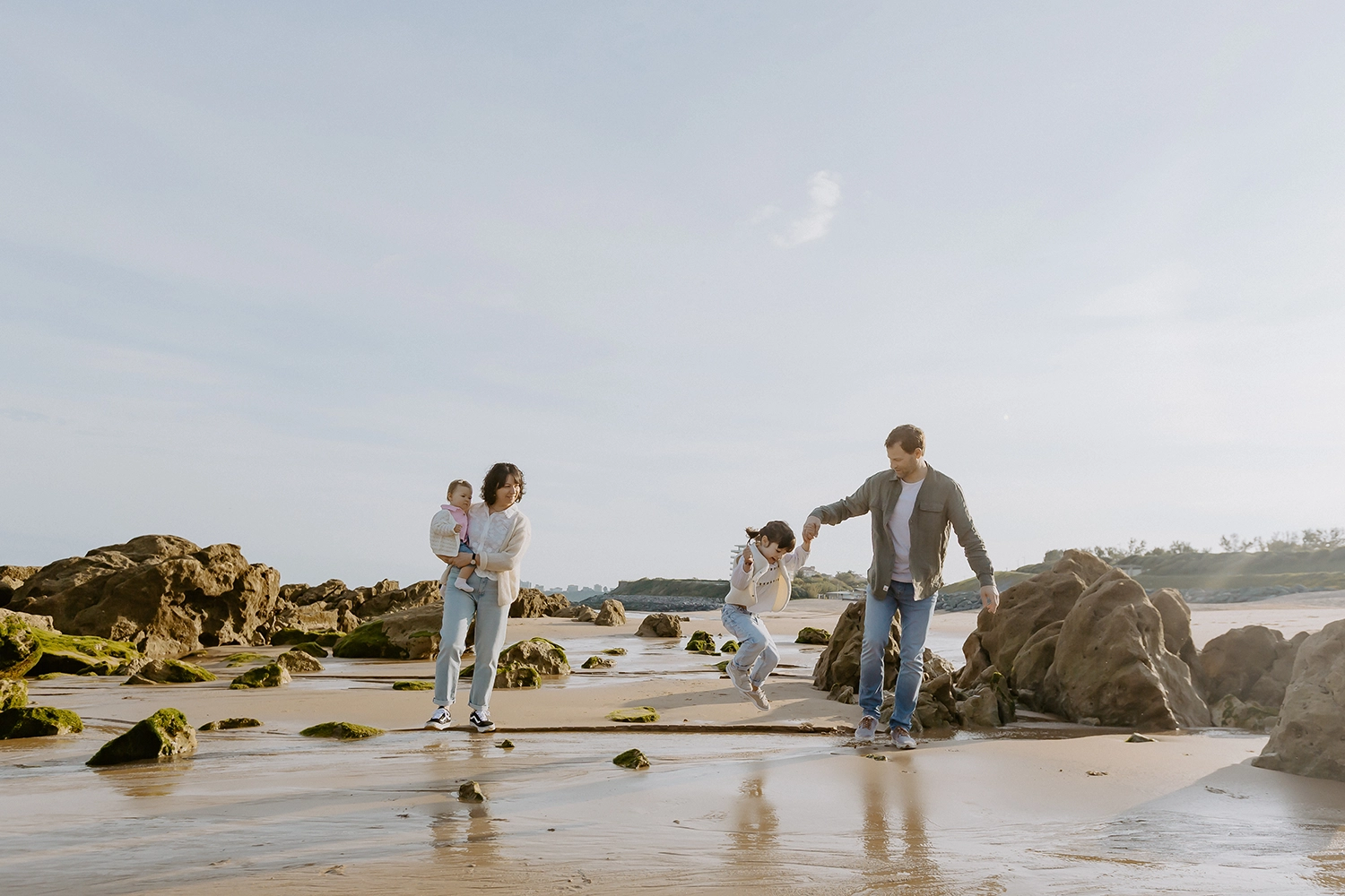 Famille unie sur le sable durant une séance de photos de famille sur la plage à Biarritz