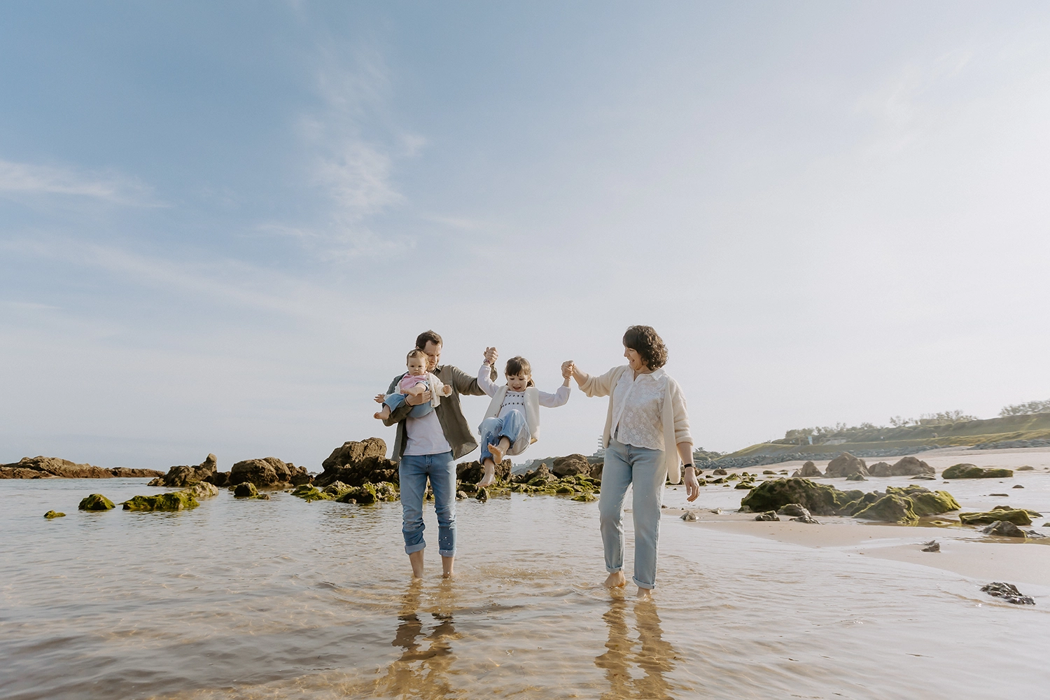Famille unie sur le sable durant une séance de photos de famille sur la plage à Biarritz