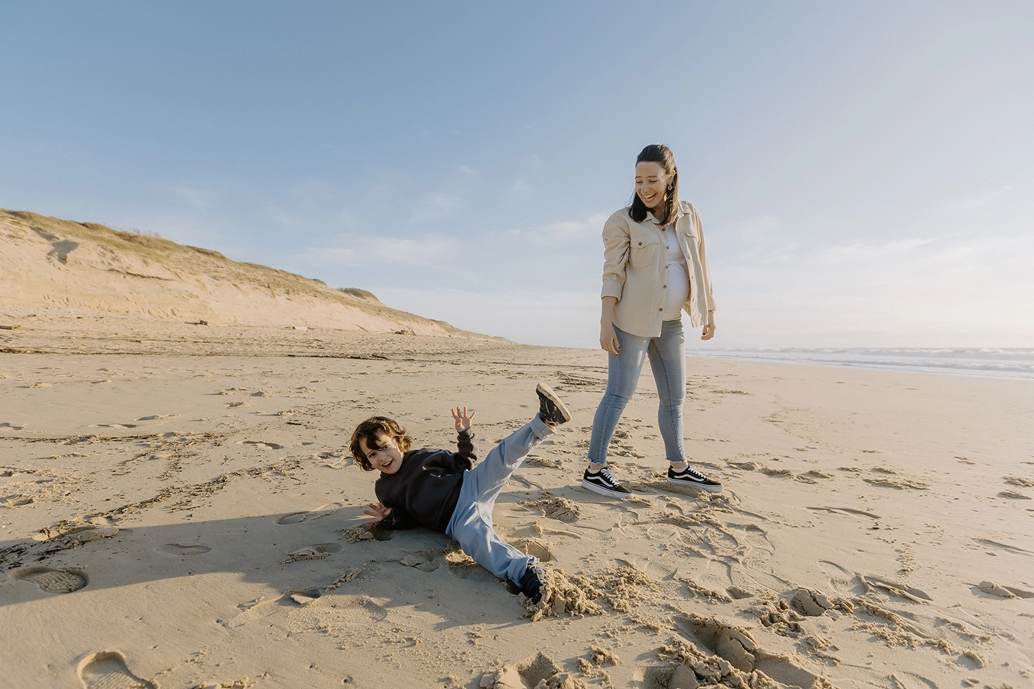 Famille sur la plage de Seignosse lors d’une séance photo grossesse en hiver.