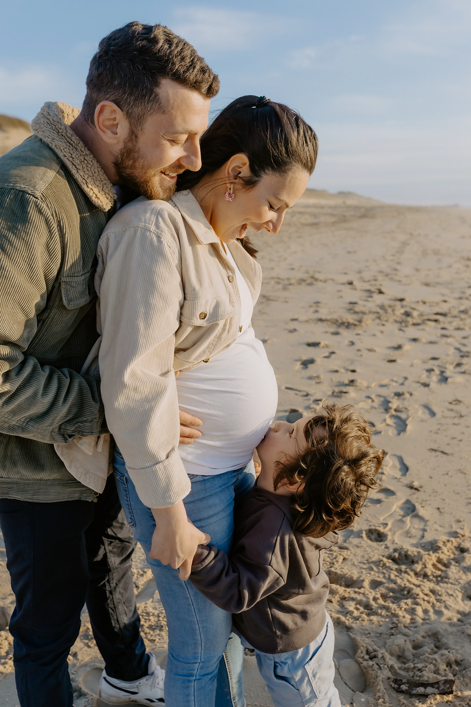 Famille sur la plage de Seignosse lors d’une séance photo grossesse en hiver.