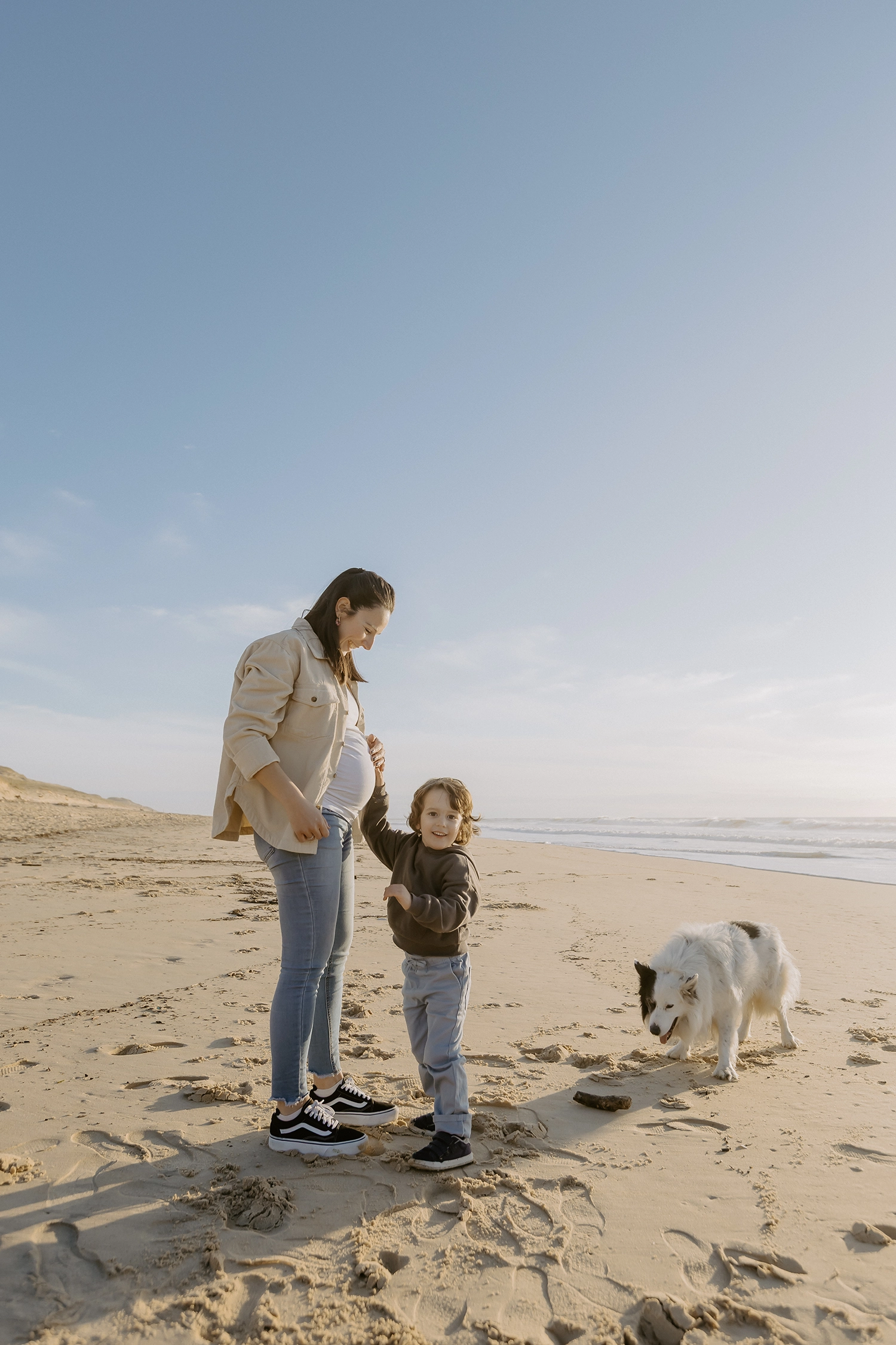 Famille sur la plage de Seignosse lors d’une séance photo grossesse en hiver.