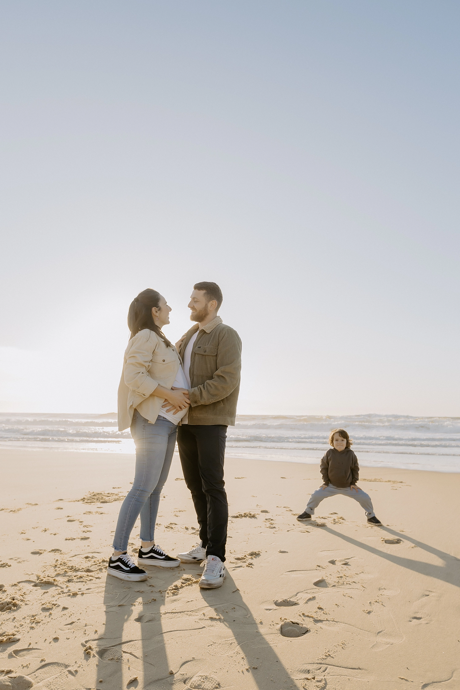 Famille sur la plage de Seignosse lors d’une séance photo grossesse en hiver.