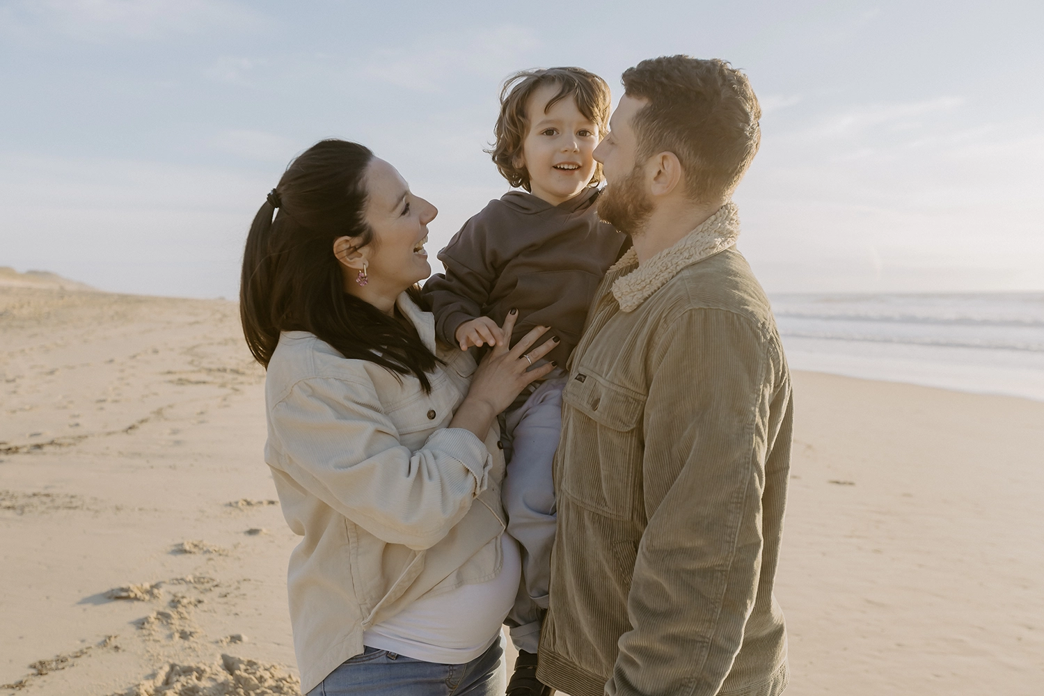Famille sur la plage de Seignosse lors d’une séance photo grossesse en hiver.