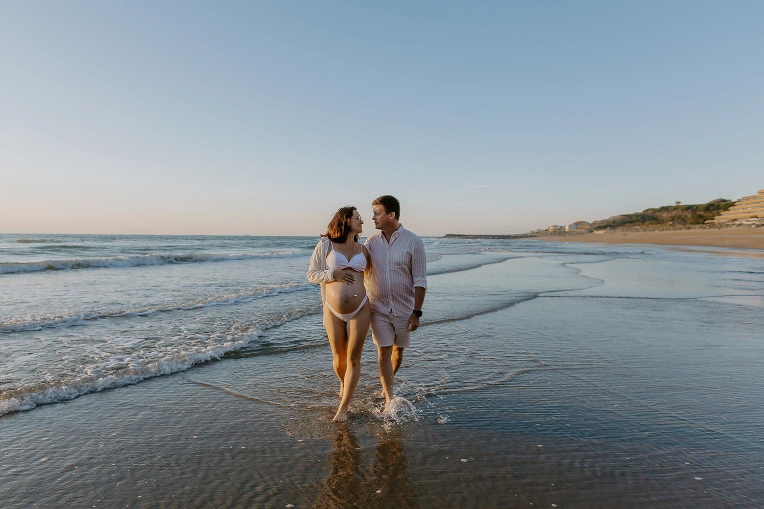 Future maman pendant une séance photo grossesse sur la plage d'Anglet