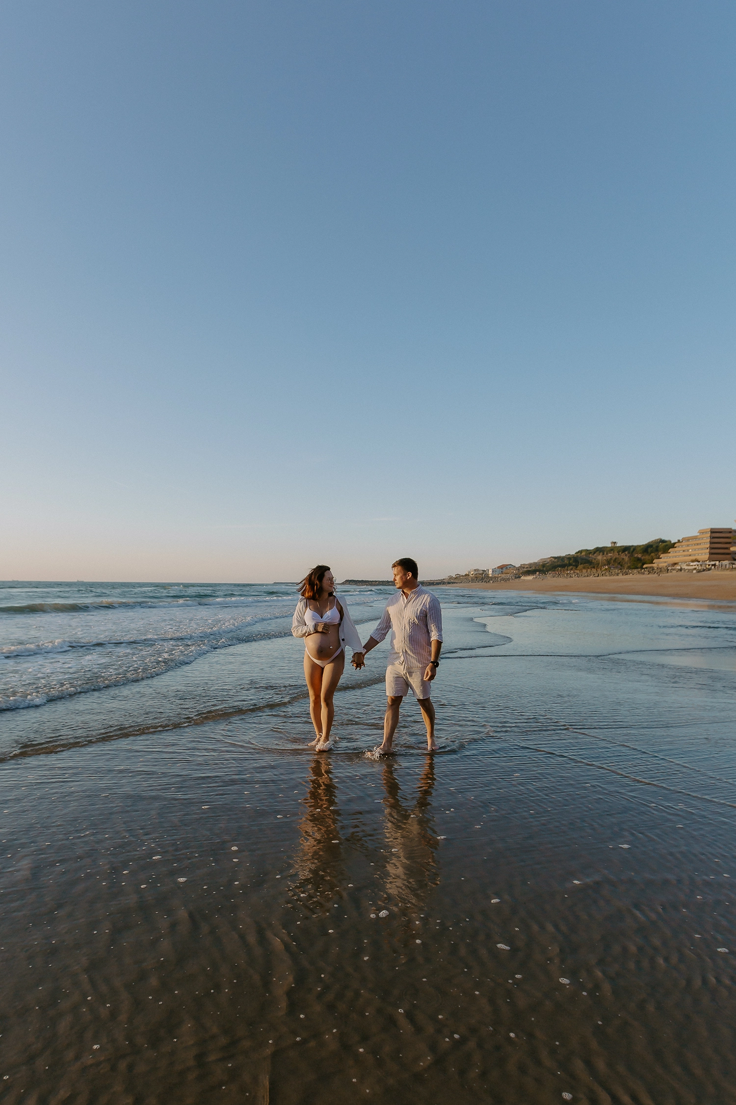 Future maman pendant une séance photo grossesse sur la plage d'Anglet