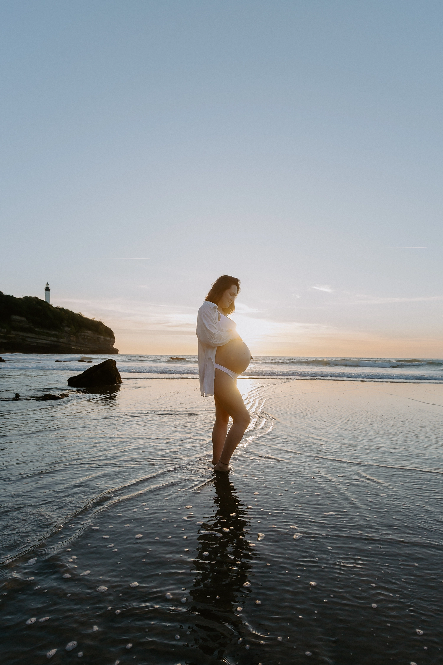 Future maman pendant une séance photo grossesse sur la plage d'Anglet